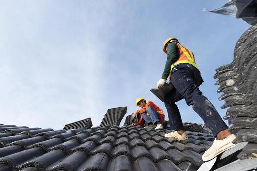 builders-in-work-clothes-install-new-roofing-tools-roofing-tools-electric-drill-and-use-them-on-new-wooden-roofs-with-metal-sheets-photo